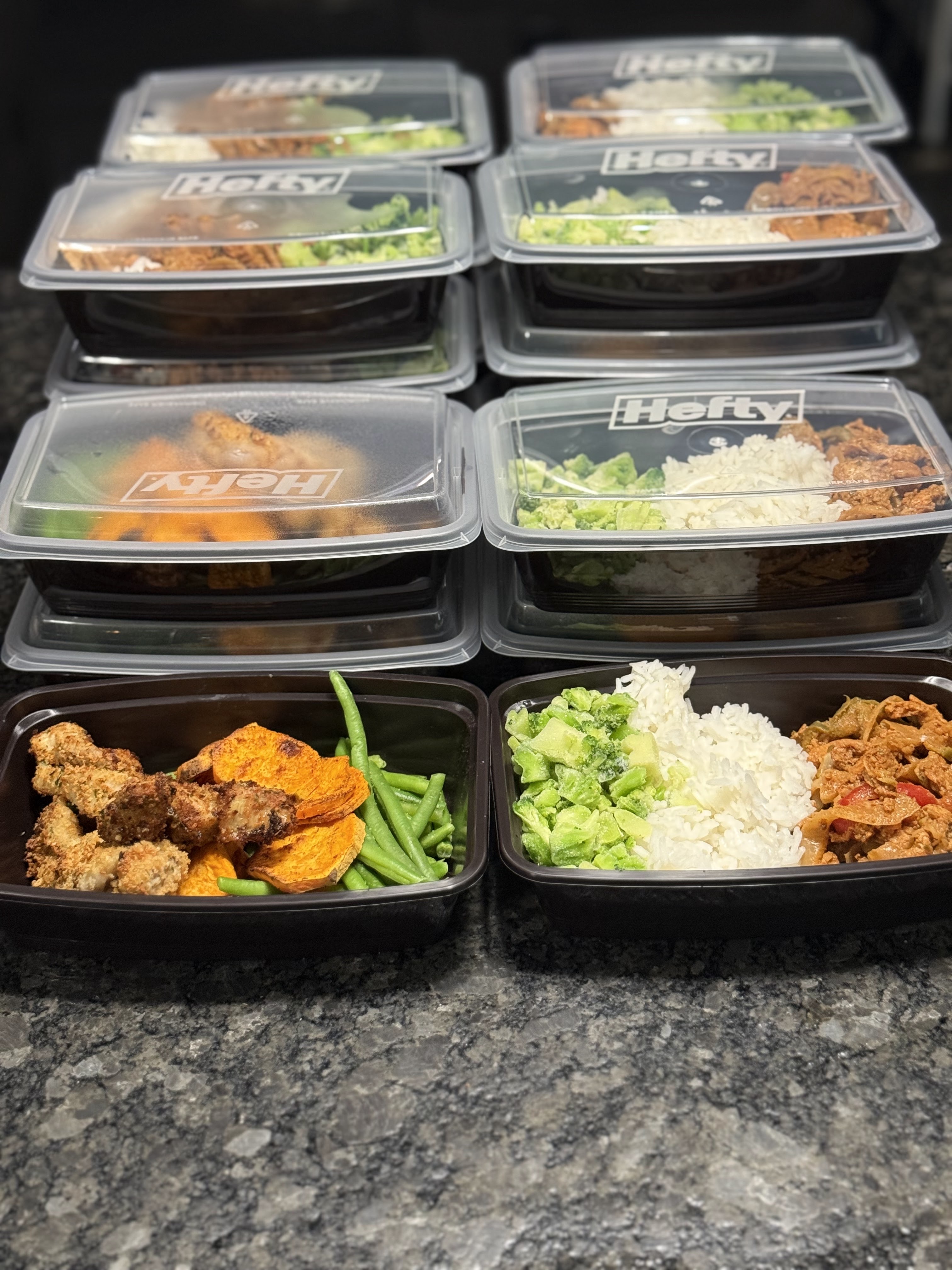 Stacks of packaged Clean Vibez meals with vegetables, rice, and protein