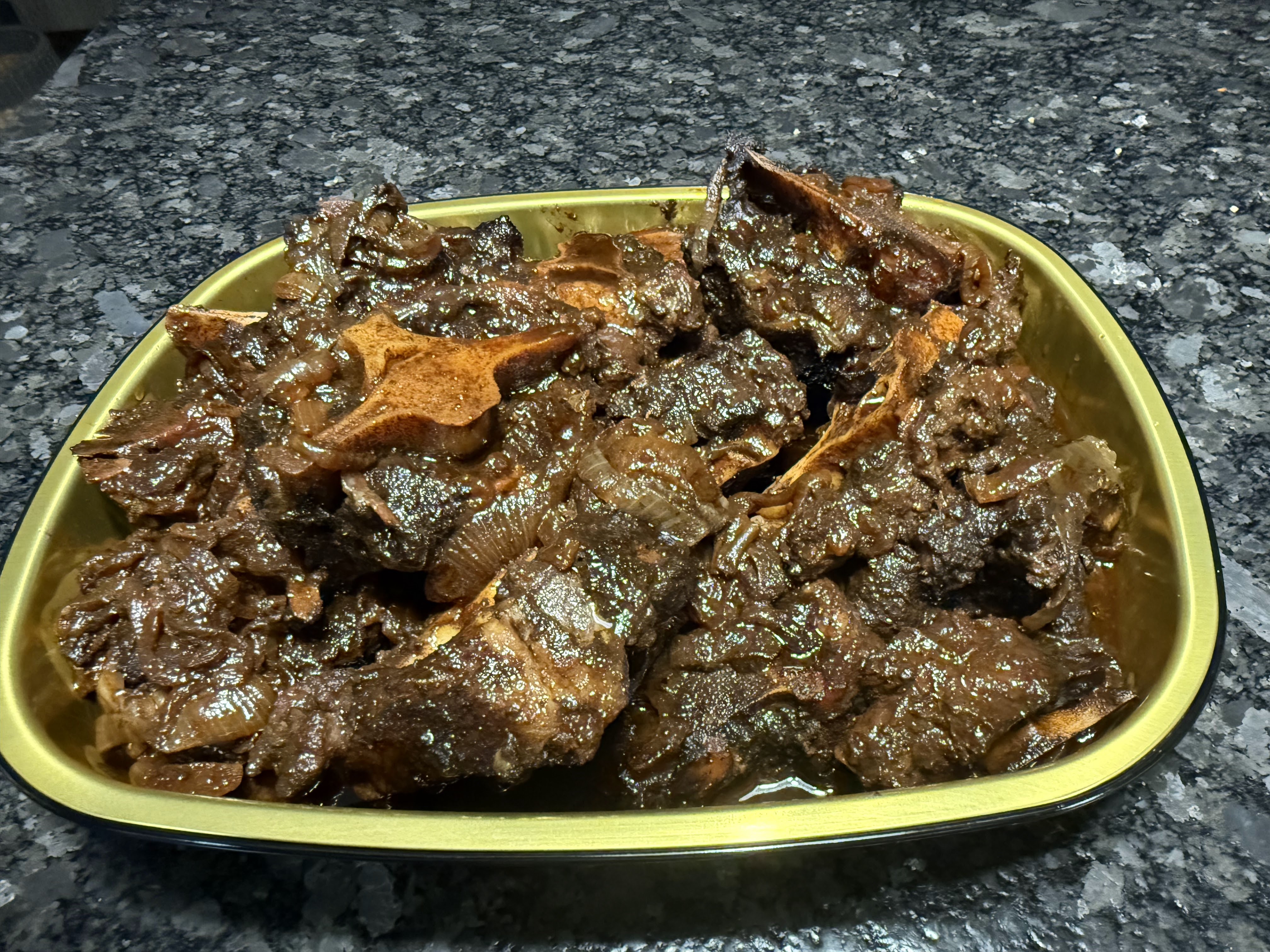Braised chops and onions presented in a gold catering tray