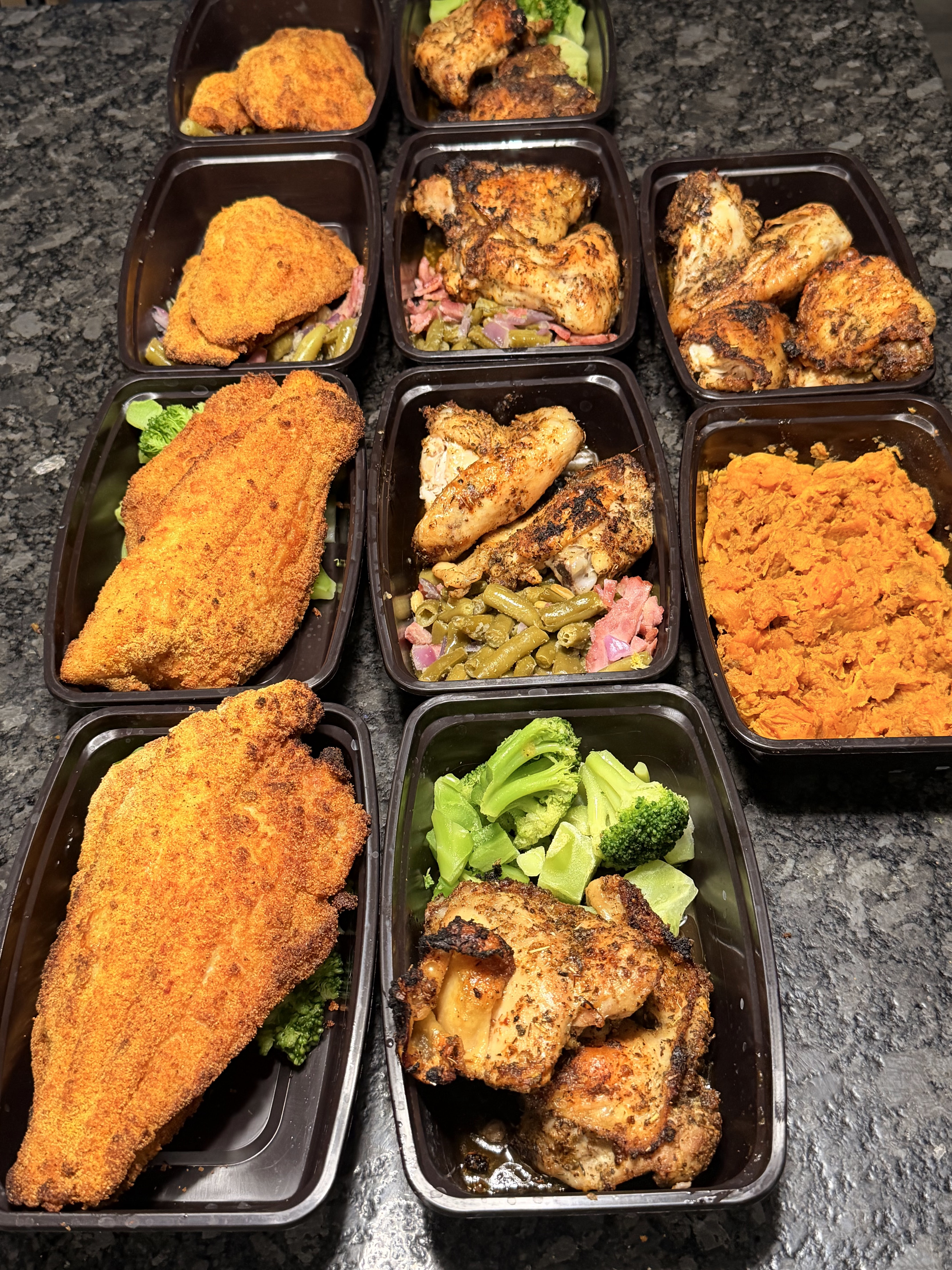 Assorted chicken, fish, vegetables, and sweet potato meal prep portions