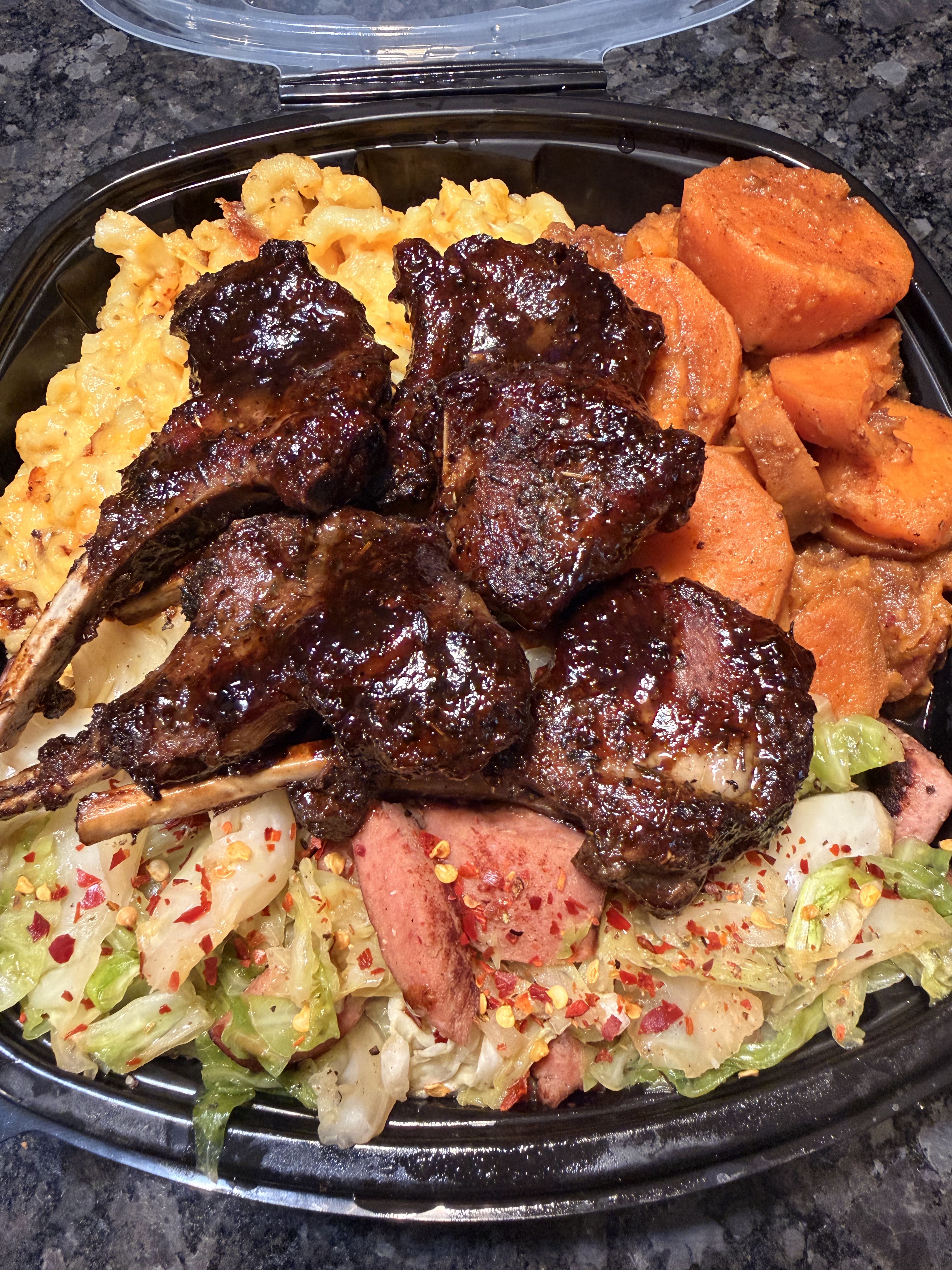 Glazed lamb chops with macaroni, sweet potatoes, cabbage, and sausage