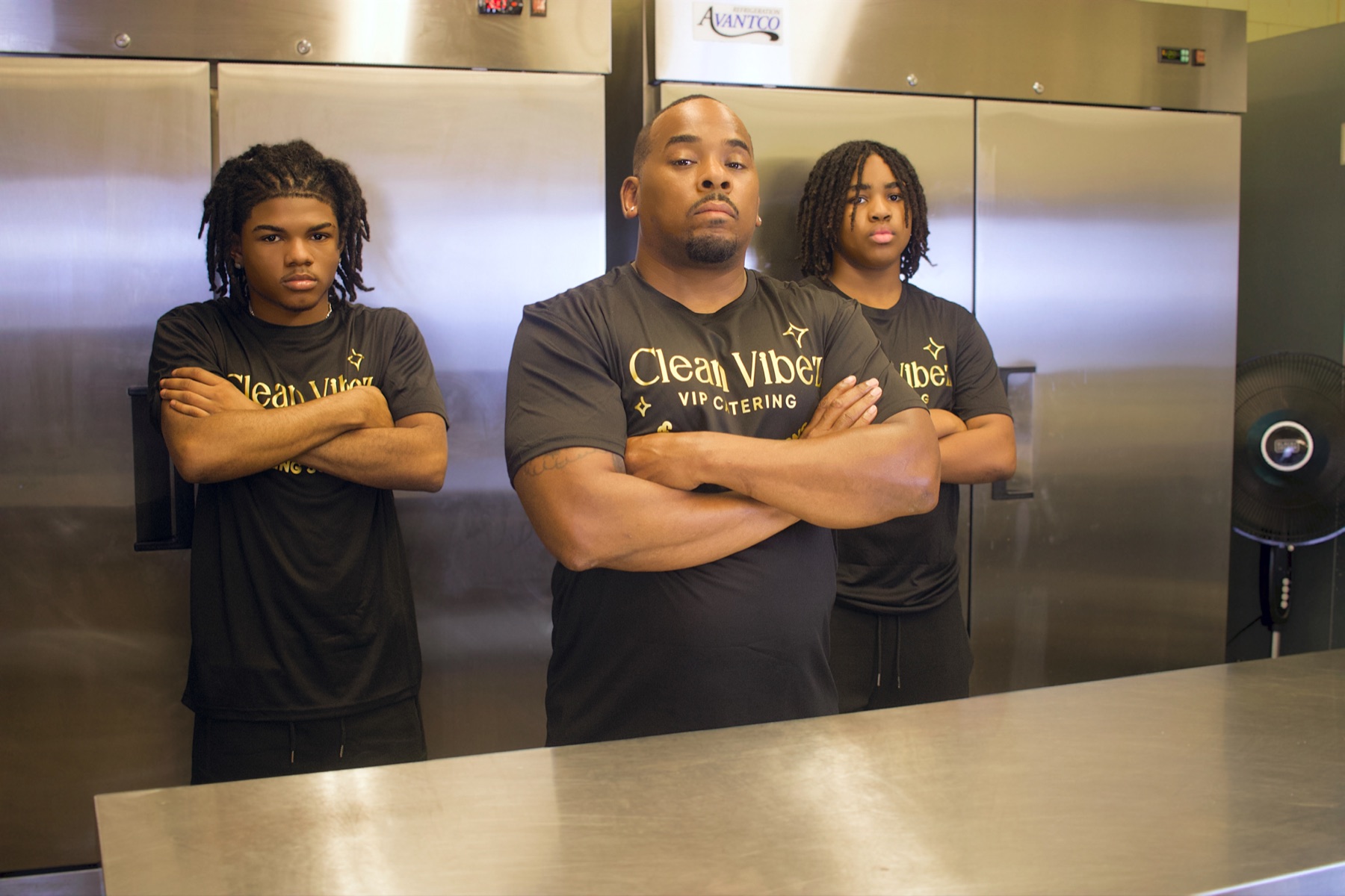 Clean Vibez team posing together in front of commercial kitchen equipment